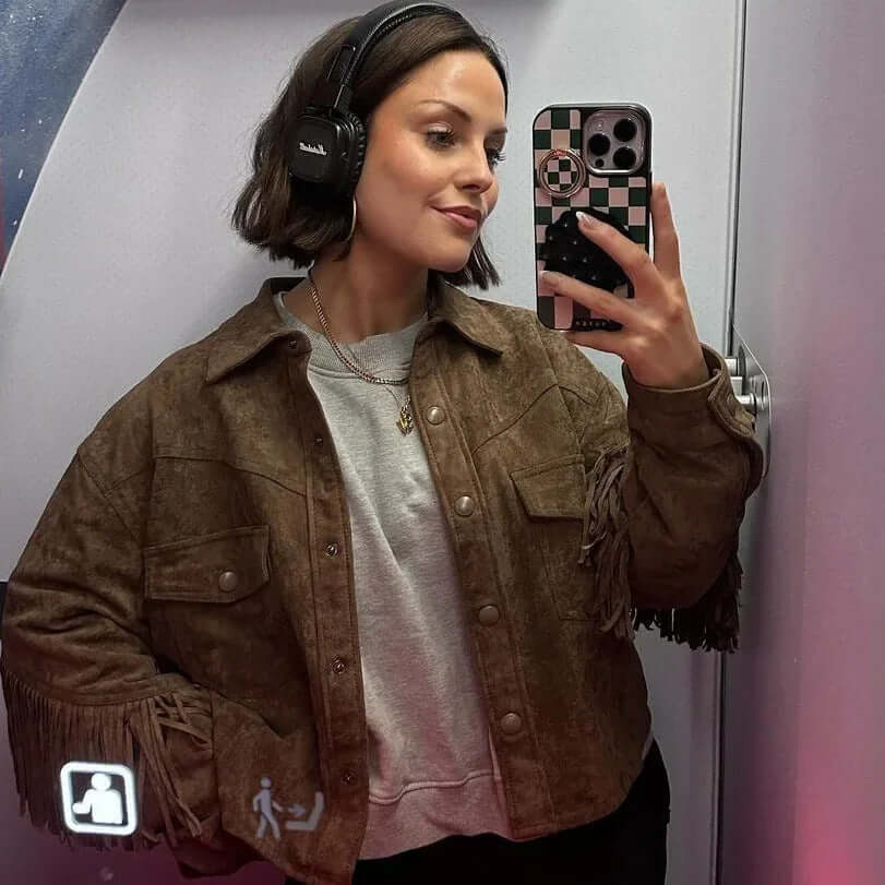 Brown suede fabric jacket with fringe, styled over a gray sweatshirt, perfect for urban street fashion.