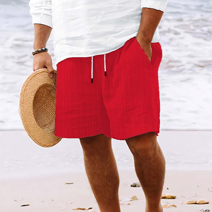 Red summer fashion drawstring shorts on a man by the beach, perfect for warm-weather style and comfort.