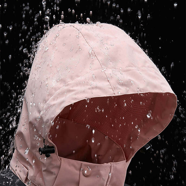 Close-up of the waterproof hood of a pink windbreaker jacket, showing water droplets beading on the surface.