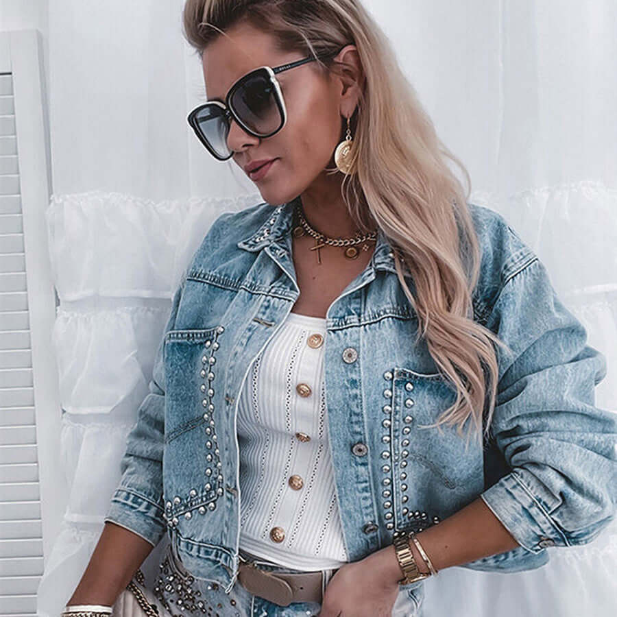 Stylish woman wearing a women's autumn street denim jacket with studs, sunglasses, and layered jewelry.