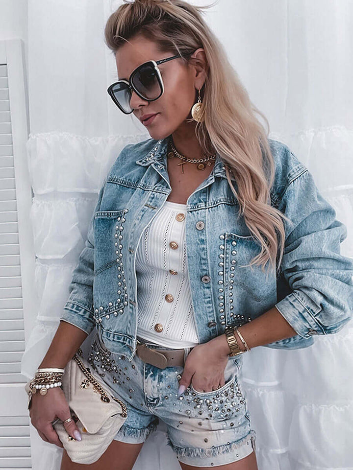 Stylish woman in a denim jacket and shorts, showcasing autumn street fashion with accessories and sunglasses.